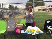 Staff member holding library cards at community picnic