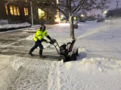 Worker removing snow from walkway