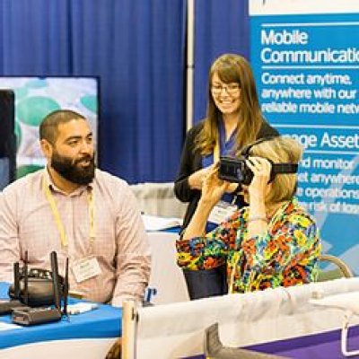 Event attendees in a vendor booth trying on VR headset