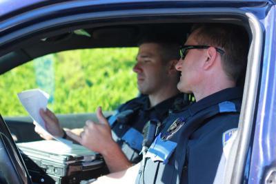 Officers reviewing paperwork in a patrol car